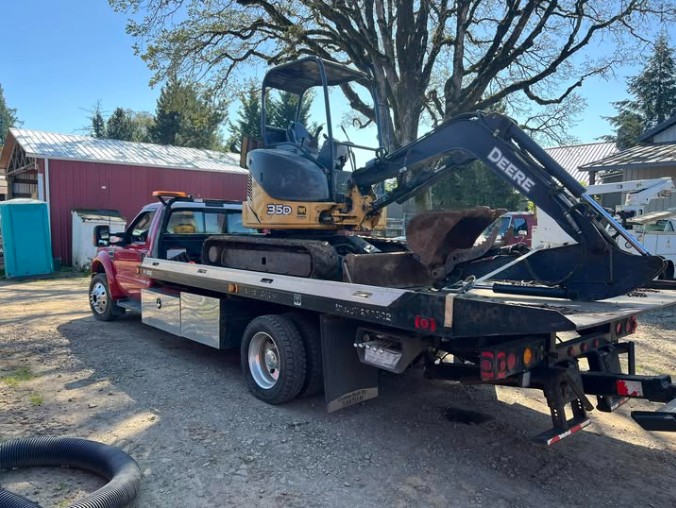 Otto Kings flatbed transporting John Deere excavator